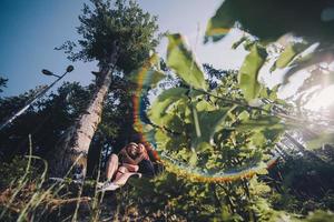 lindo casal sentado em uma floresta perto da árvore foto