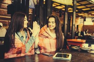 duas meninas jovens e bonitas se divertindo no café foto