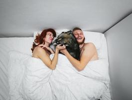 casal adulto jovem deitado na cama foto