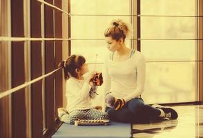 mãe e filha brincando com brinquedos no ginásio foto