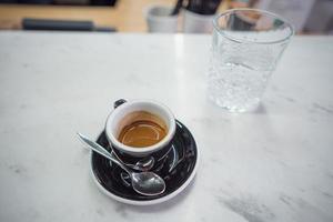 caneca de café e um copo de água em uma mesa foto