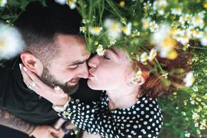 jovem casal encontra-se no campo com margaridas. foto