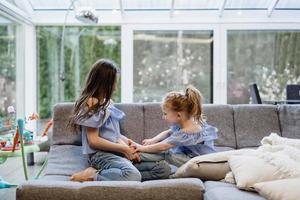 duas irmãs brincando juntas no grande sofá foto