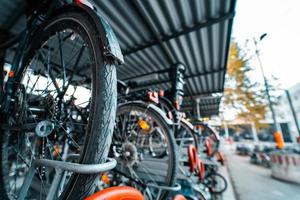 muitas bicicletas seguidas. estacionamento de bicicletas na rua foto