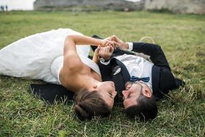casal de noivos deitado na grama foto