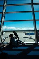 garotinho e sua mãe sentados em um aeroporto foto