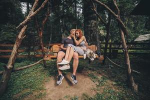 lindo casal junto com cachorro em um balanço foto