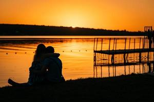 jovem casal descansando na margem do rio foto