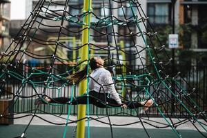 jovem se divertindo na pirâmide de corda foto