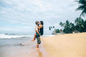 um cara e uma garota estão se beijando na praia foto