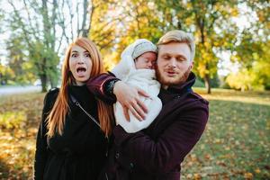 jovem família e filho recém-nascido no parque outono foto