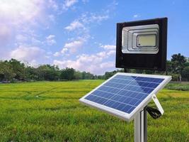 um holofote fotovoltaico usa energia solar no meio de um campo de arroz. conceito de energia pura foto