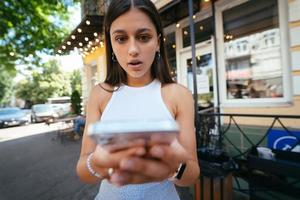 mulher bonita uma rua urbana para ler um sms em seu celular foto