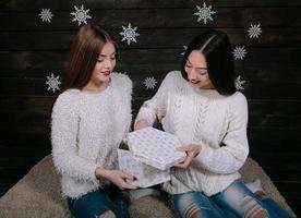 duas lindas garotas juntas desembalar presentes foto