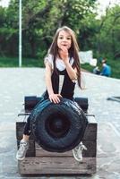 menina pré-escolar sentada em cima de um canhão foto