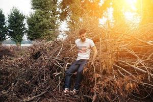 o homem de botas autênticas e jeans de ourela em um fundo de galhos foto