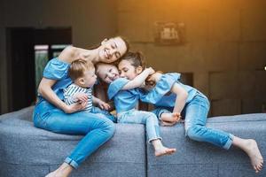 mãe, duas filhas e um filho pequeno no sofá