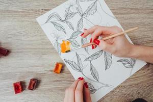 jovem mulher pintando com tintas aquarela foto