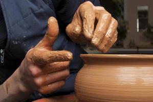 mãos do oleiro, criando um pote de barro
