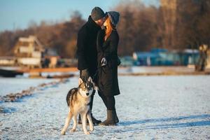 casal com cachorro na neve foto