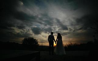 silhueta de casal de noivos em campo foto
