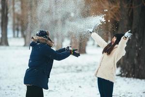 menino e menina brincando com neve foto