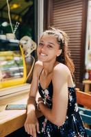 atraente jovem mulher caucasiana sentada no café de rua foto