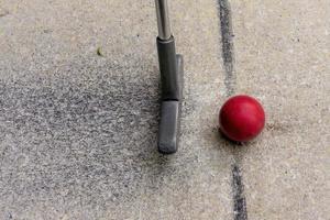 clube de golfe em miniatura com bola vermelha foto
