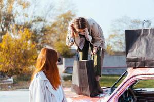 mulheres jovens posando perto de um carro antigo decorado foto