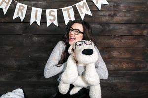 menina bonitinha abraçando um brinquedo fofo. fundo de natal foto