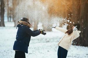 menino e menina brincando com neve foto