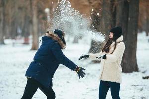 menino e menina brincando com neve foto