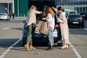 mulheres jovens no carro com sacolas de compras foto