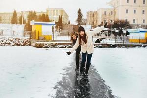 homem e mulher patinam no gelo foto