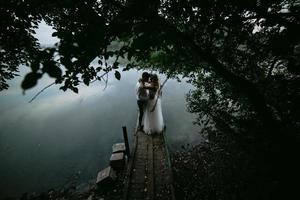 casal de noivos no velho cais de madeira foto