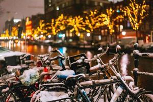 bicicletas estacionadas ao longo de uma ponte sobre os canais de amsterdã foto