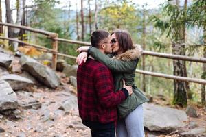 menina e um jovem se beijando na floresta foto