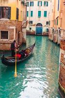 canal veneziano com casas antigas e barcos foto