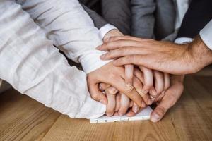 mãos unidas da equipe de negócios no fundo do espaço de trabalho foto