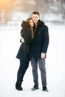 casal posando em um parque nevado foto