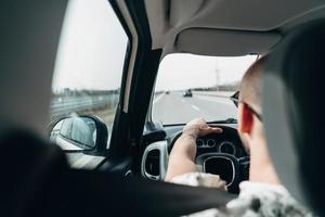 o homem no carro viajando na estrada foto