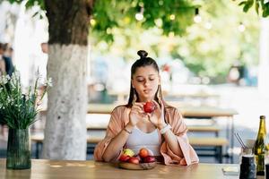 mulher jovem e bonita hipster sentado na varanda café na rua. foto