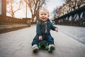 menino engraçado com skate na rua foto