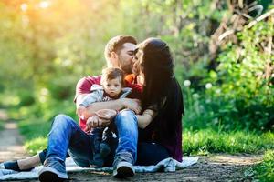 jovem família com uma criança na natureza foto