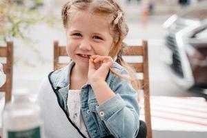 menina em um café de rua com batatas fritas foto