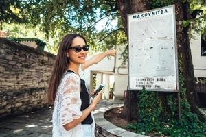 mulher aponta para o mapa de marcos da cidade. makrinitsa foto