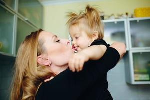 mãe com filha em pé na cozinha foto