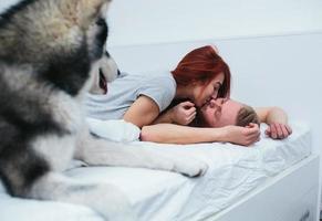 casal adulto jovem deitado na cama foto