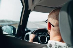 o homem no carro viajando na estrada foto