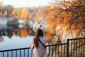 garota de outono em pé para trás e observando a natureza. foto